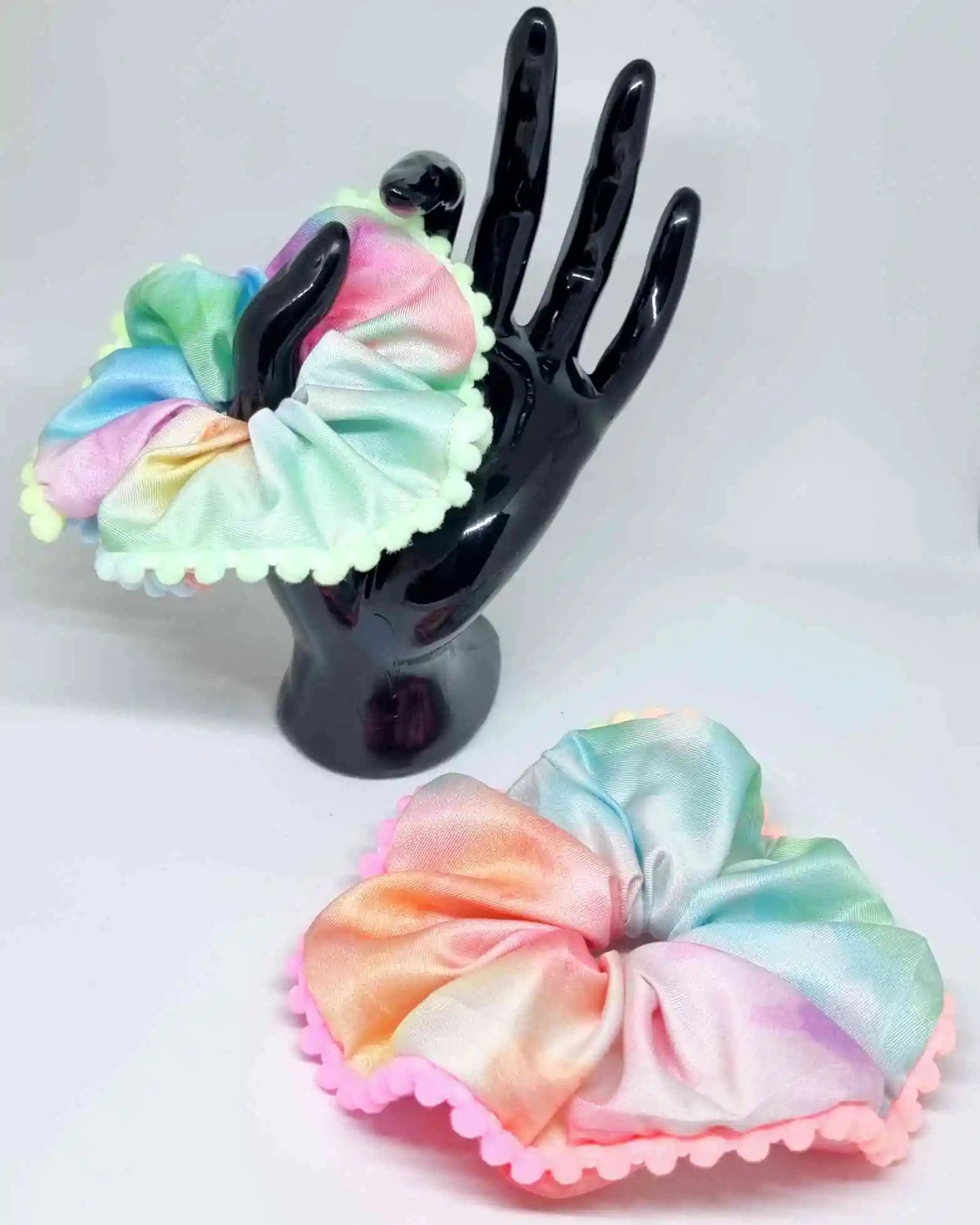 Scrunchie Tye Die BorlasScrunchie Tye Die Borlas es ideal para mantener tu cabello organizado a la vez que lo cuidas. Hecho a mano con borlas decorativas, este coletero con estampado tye die único, es ideal para añadir un toque particular a tu look. Tamañ