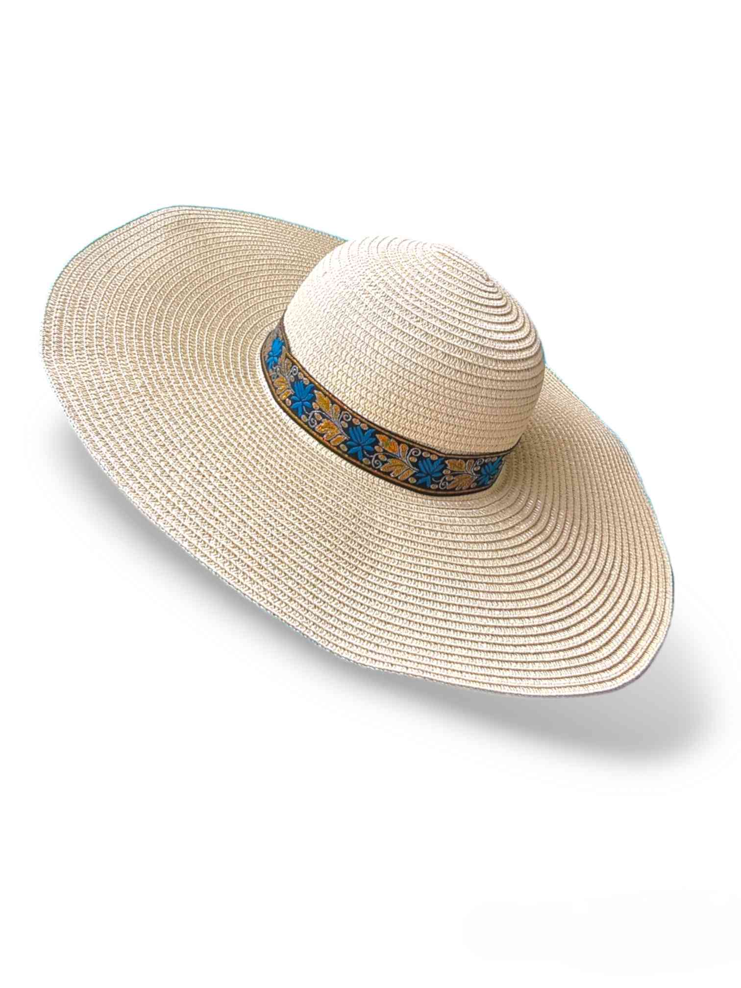 Sombrero Verano Beige Azara | Sommerhut DamenSombrero de verano beige Azara ¡Alegra tu verano con el sombrero Azara! Un sombrero divertido para mujer con un estilo único. Color crema con cinta a contraste en tonos dorado, azul y un fondo negro. Este sombr