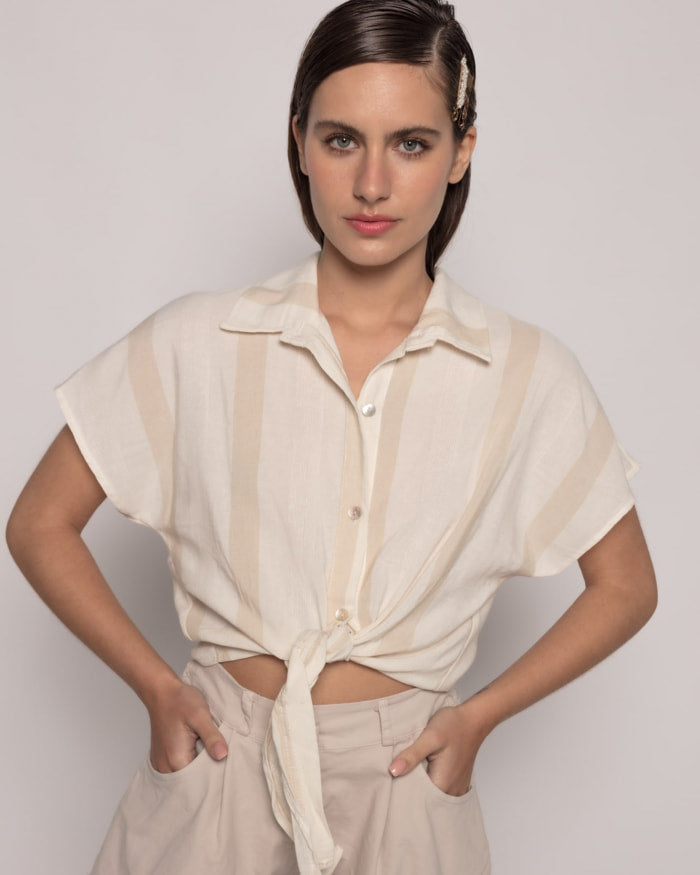 Camisa Alegria Rayas NudoCamisa semi-crop anudada Camisa de rayas con cuello solapa y manga corta. Cierre frontal con botones. Detalle nudo frontal. Talla de la modelo: S. Altura modelo: 1,65 m. Composición: 100% Algodón Envío: Suiza 2/3 días Europa 5/9 d