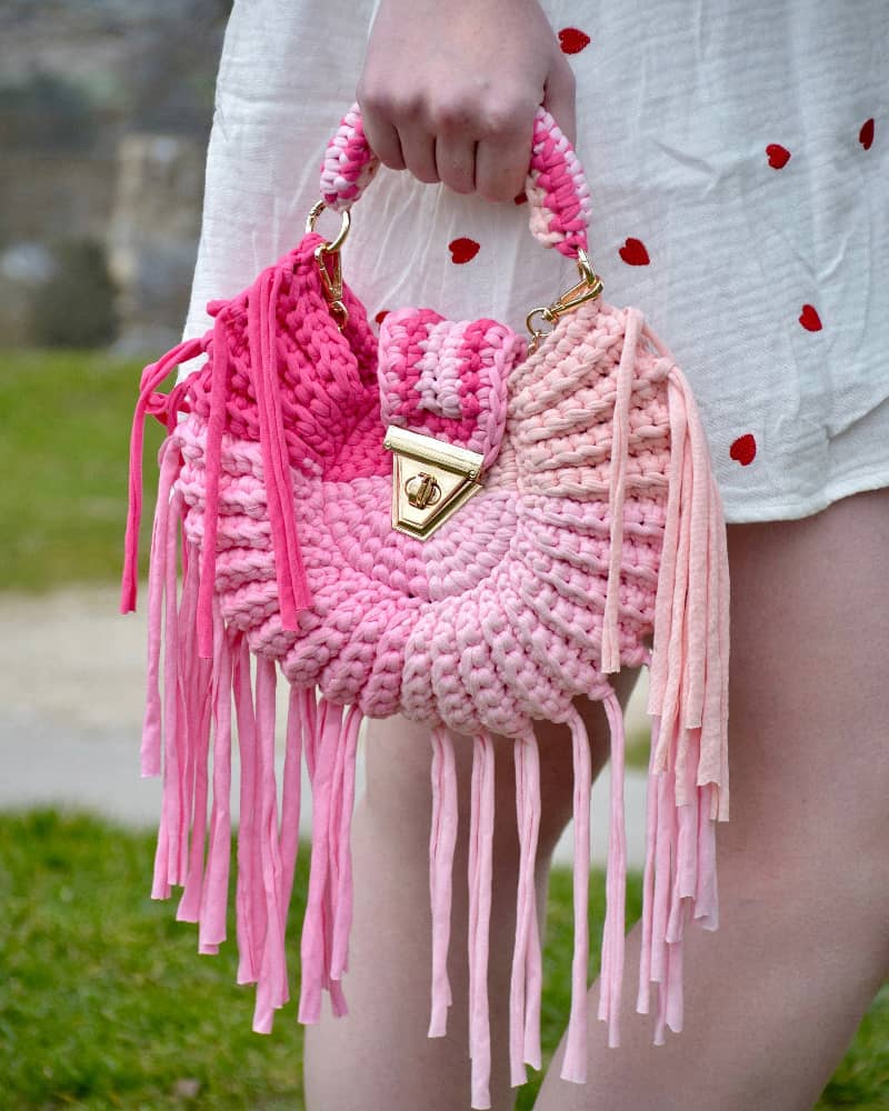 Bolso Tejido Chic LiliesBolso Tejido Crochet Chic Lilies Eleva tu estilo con el Bolso Tejido Chic Lilies. Su diseño en tonos rosados y su asa en el mismo material, cierre en contraste color gold, lo hacen sofisticado y exclusivo. Además, su cadena permite