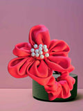 Scrunchie Satinado Pearl Glam | Haargummi Silk Pearl GlamHaargummi Satin Pearl ¡El Scrunchie Satinado Pearl Glam es el complemento perfecto para un look glamuroso! Un coletero elástico con forma flor con perlas decorativas. ¡Elegante, sofisticado y versát