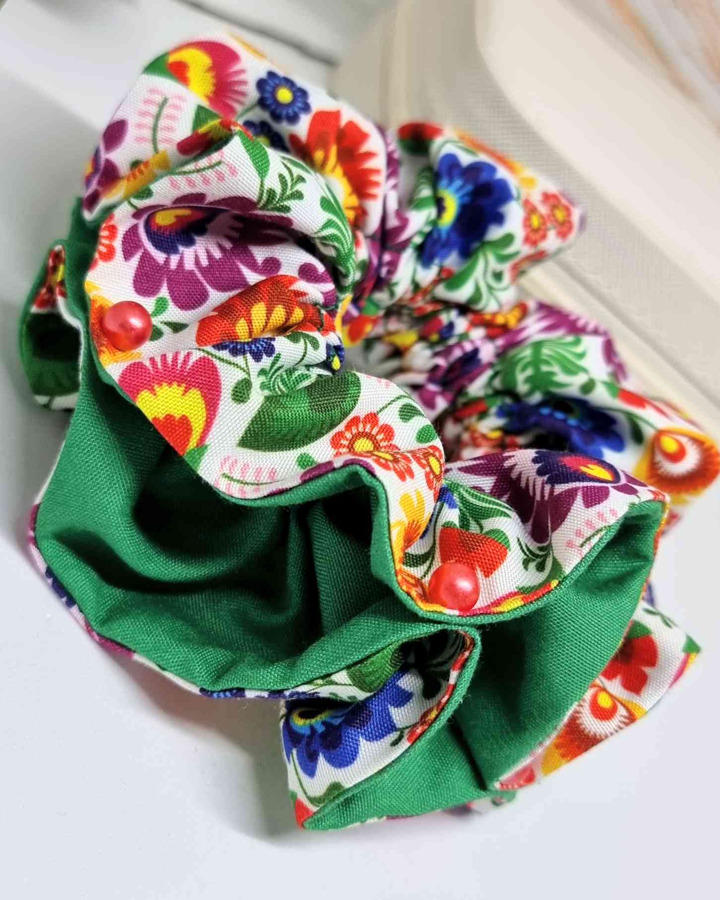 Scrunchie Especial Glam Mexico | HandmadeColetero edición especial Mexico Este coletero hecho a mano es una perfecta solución para el cabello. Realizado con un doble tejido premium, cuenta con perlas decorativas para un toque glamoroso. Con su estampado i