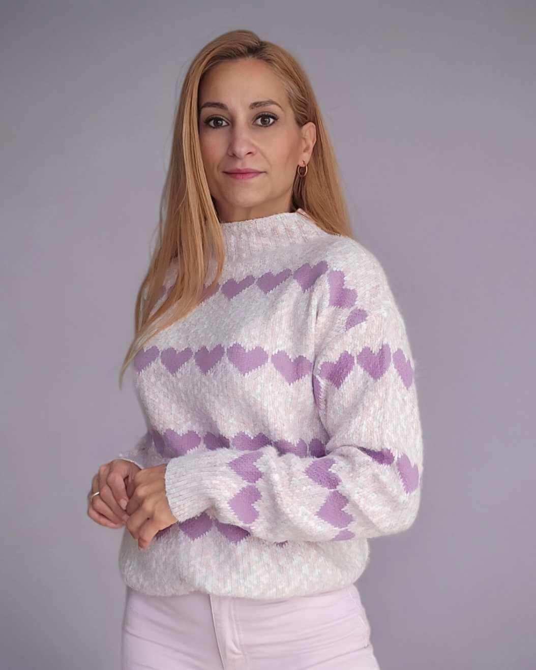 Pullover Jersey Cuori PinkEste jersey suave cuenta con un diseño de cenefas con corazones en contraste, presentando un estilo único y femenino. Con corazones lila y un fondo jaspeado en tonos blanco, gris y rosa, este jersey es ideal para añadir un toque