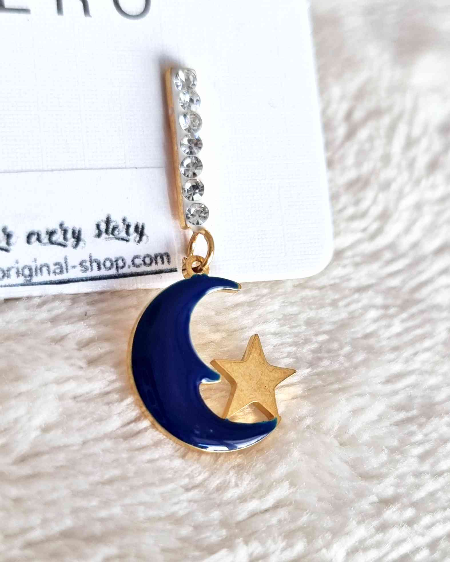 Pendientes Luna NocheEstos pendientes colgantes Luna Noche son una combinación perfecta de elegancia y estilo. Hechos con acero de calidad superior, estos pendientes se caracterizan por sus hermosos diseños de luna y estrella, adornados con brillos delica