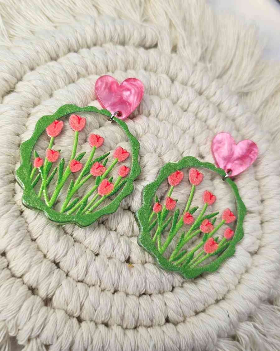 Pendientes Tulipanes Pink | Tulpen OhrringeLos Pendientes Tulipanes Pink son una hermosa joya adornada con elegantes tulipanes en tonos verdes y rosados sobre un fondo transparente. Añade un toque de encanto y delicadeza a tu atuendo con estos pendientes.