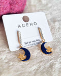 Pendientes Luna NocheEstos pendientes colgantes Luna Noche son una combinación perfecta de elegancia y estilo. Hechos con acero de calidad superior, estos pendientes se caracterizan por sus hermosos diseños de luna y estrella, adornados con brillos delica