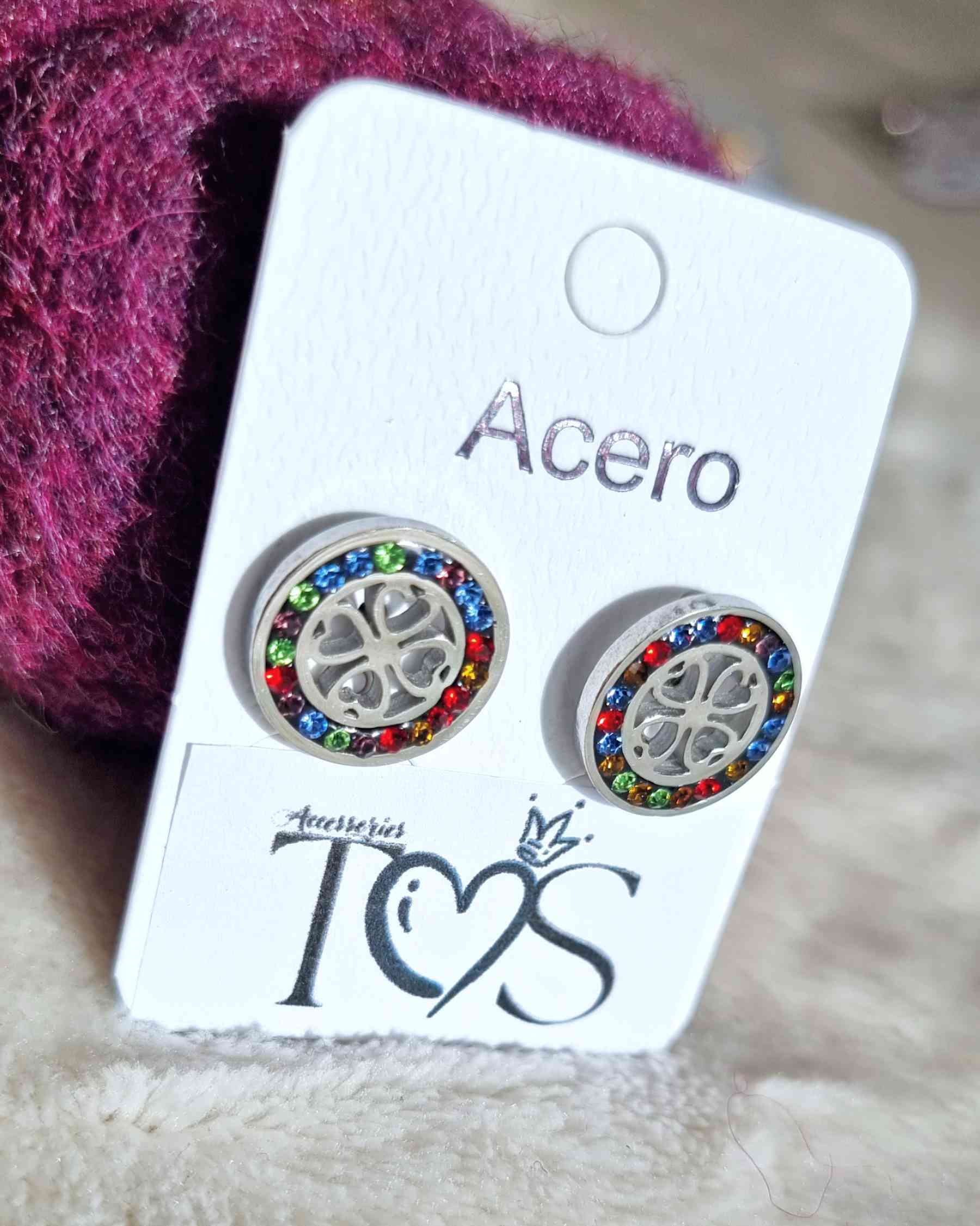 Pendientes Boton TrebolLos pendientes Boton Trebol te harán lucir radiante. Estos son delicados y llenos de un brillo intenso gracias a sus bordes decorados con brillantes de colores ¡Adorna tu look con estos bellos pendientes!. Fabricados en cero Envío: