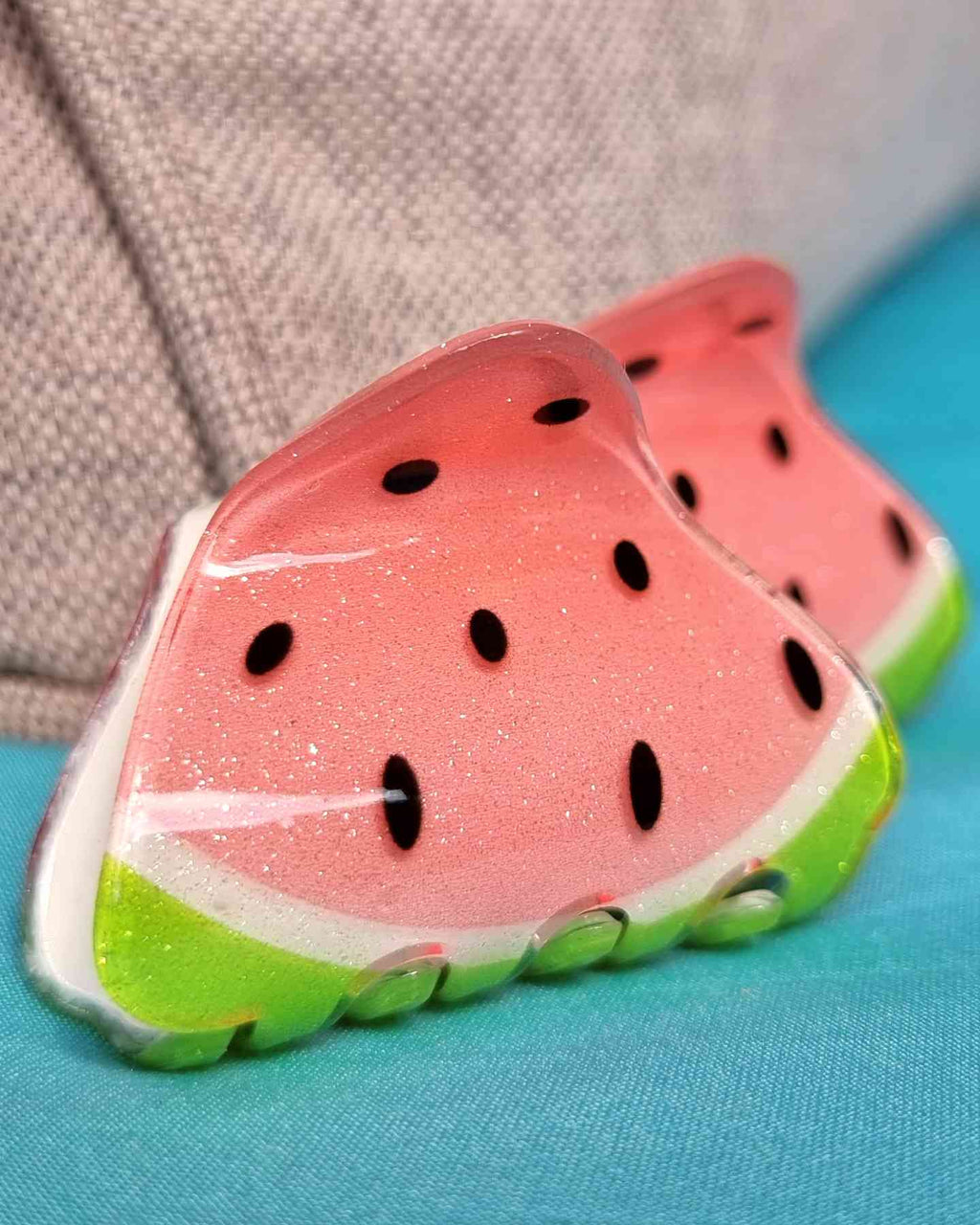 Gancho Cabello Sandia | HaarklammerPinza de pelo Sandia ¡Disfruta del verano con el Gancho Cabello Sandia! Diseñada con un divertido motivo de sandía combinado con brillantina, este gancho es único para lucir durante toda la temporada. ¡Combina tu look co