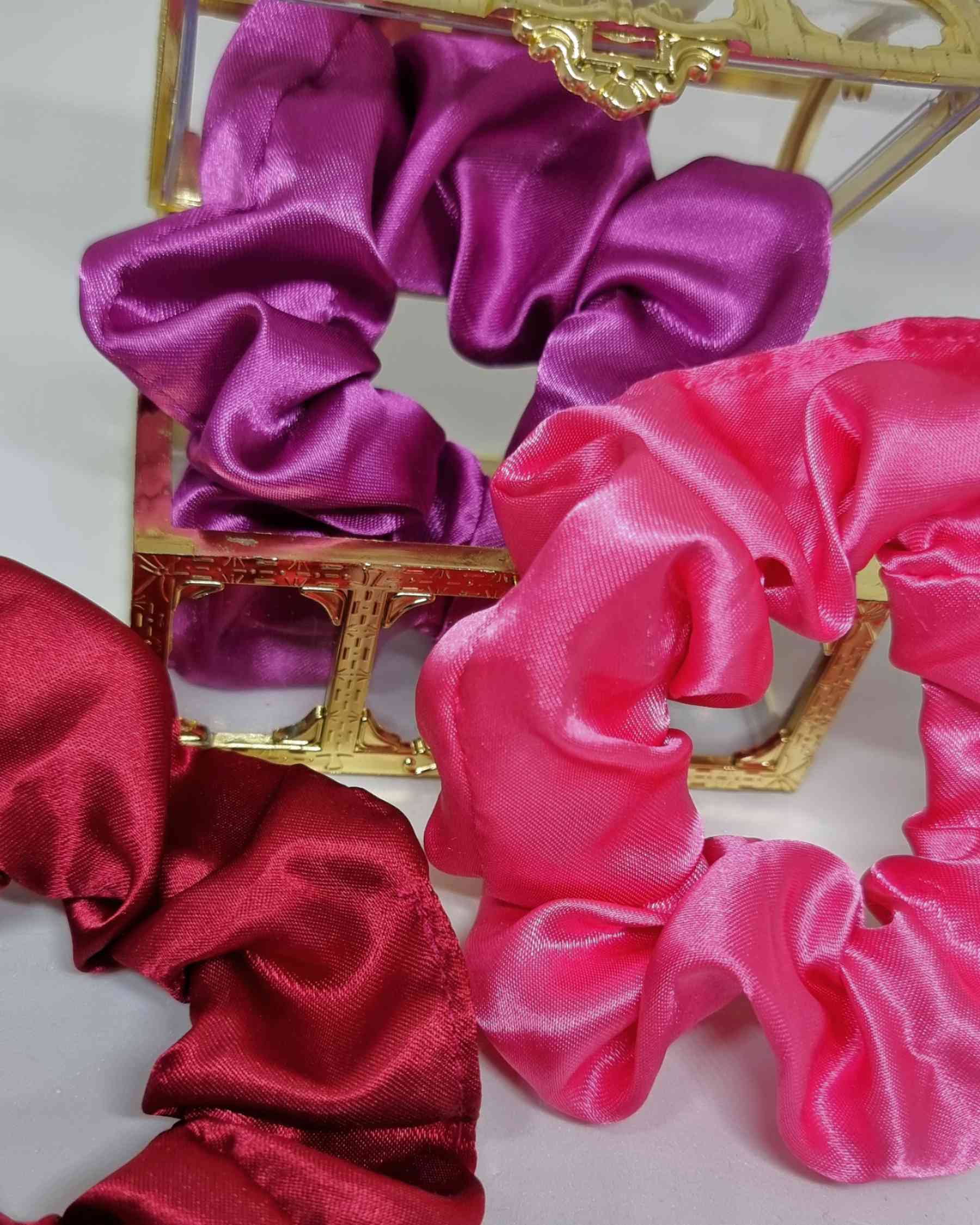 Scrunchies Box Satinado RosesColeteros Box Satinados Roses ¡Elige la diferencia con nuestra caja de scrunchies satinados en tonos rosados! Estos coleteros satinados de 10 cm, cuidadosamente hechos a mano, mimarán tu cabello evitando que se dañe y el encre