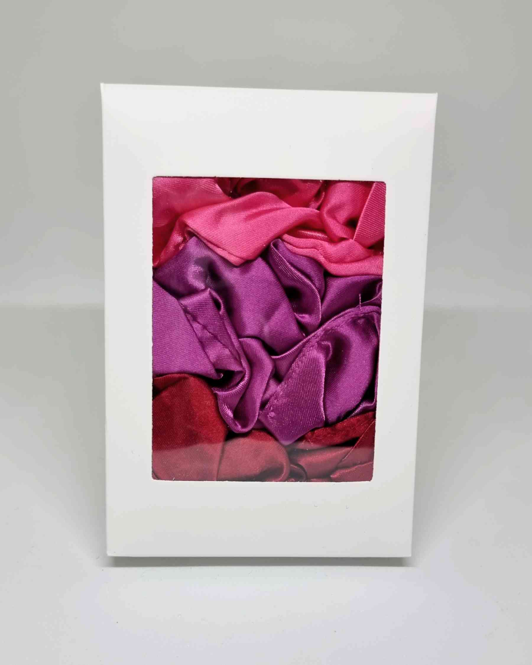 Scrunchies Box Satinado RosesColeteros Box Satinados Roses ¡Elige la diferencia con nuestra caja de scrunchies satinados en tonos rosados! Estos coleteros satinados de 10 cm, cuidadosamente hechos a mano, mimarán tu cabello evitando que se dañe y el encre