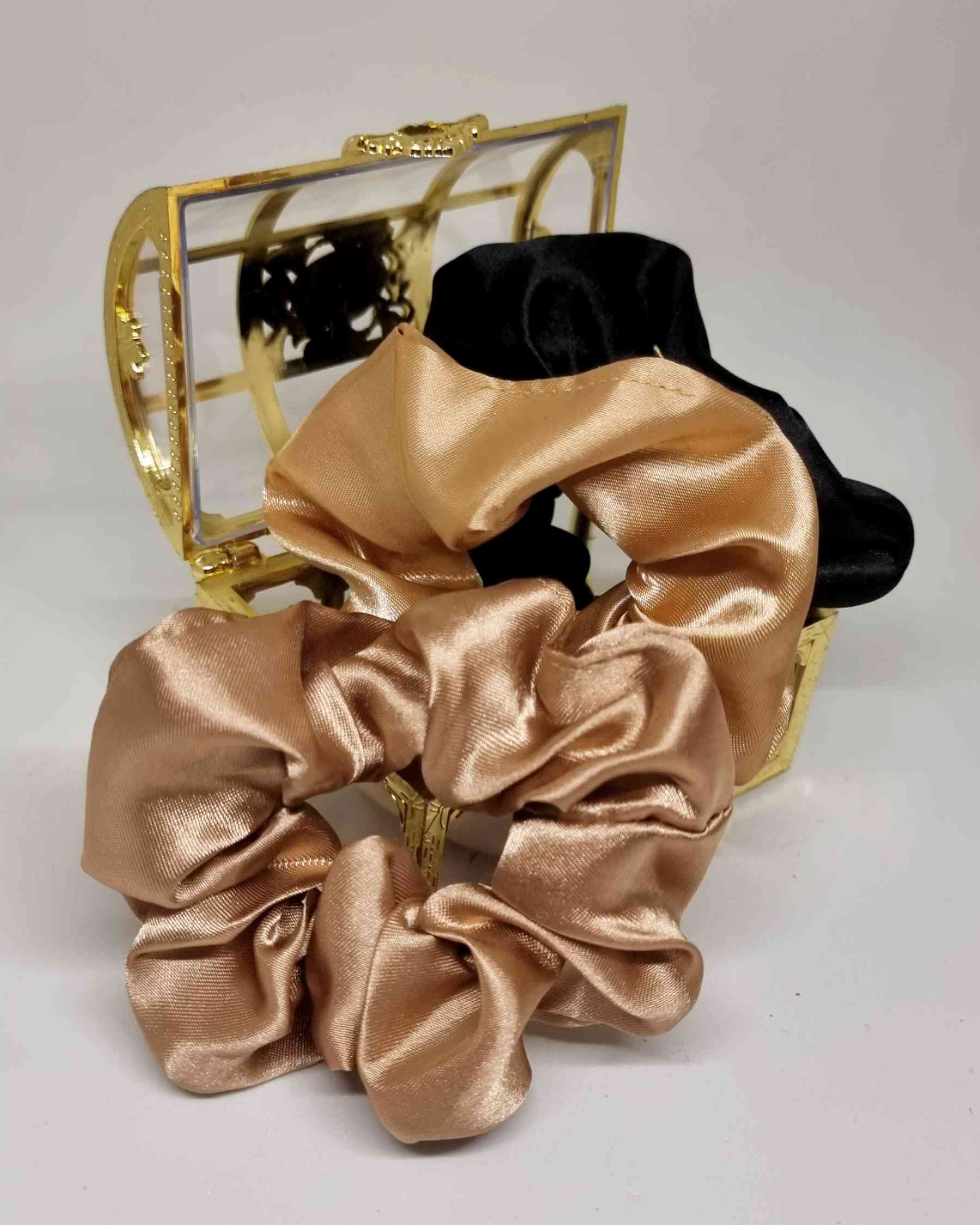 Scrunchies Glamour Satin Set | Haargummi Satin SetColeteros Glamour Satin Descubre los coleteros glamour de satén de la colección Scrunchies Glam. Estos tres coleteros con tonos dorados y negro son ideales para uso diario y miden 10 cm. Adquiérelos en caj