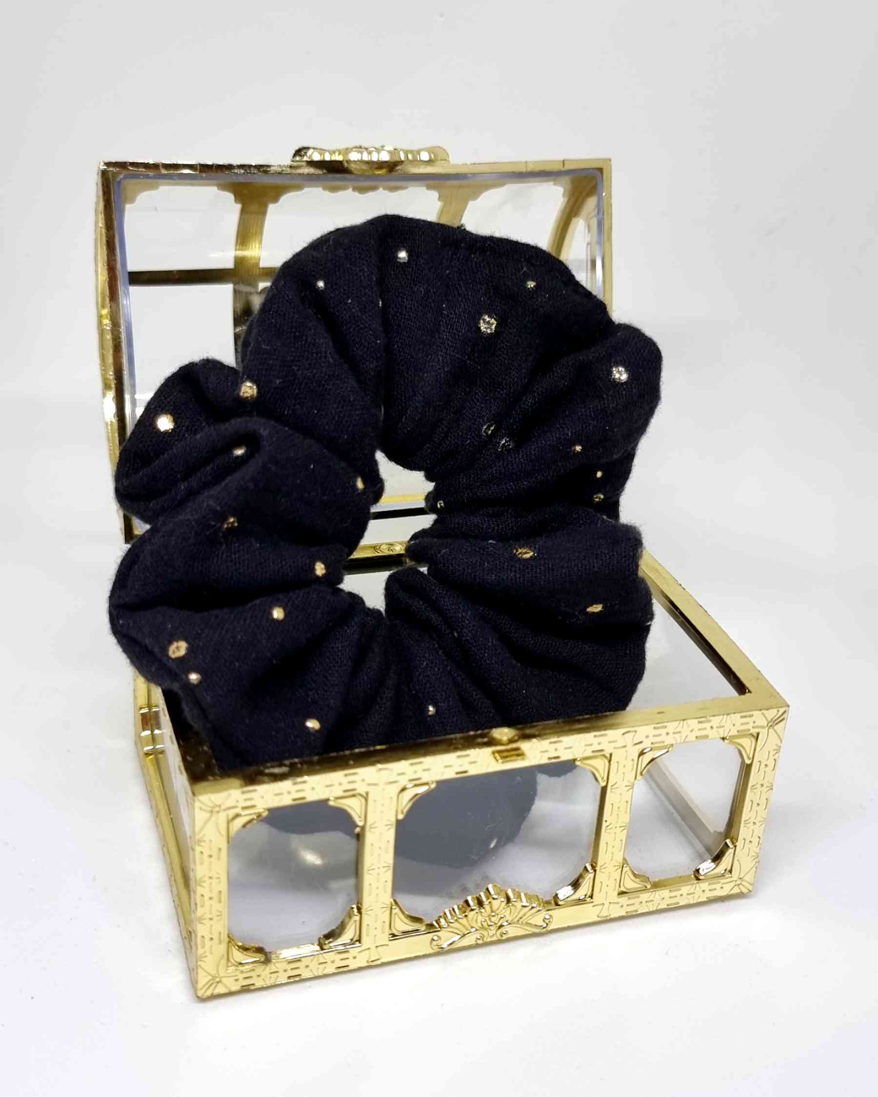 Scrunchie Muselina Negro Detalles GoldScrunchie Musselin Negro Gold Siente la comodidad y el estilo de este Scrunchie Muselina Negro Detalles Gold. Hecho a mano en una tela suave muselina, te sentirás siempre cómoda y elegante con sus detalles de lunares