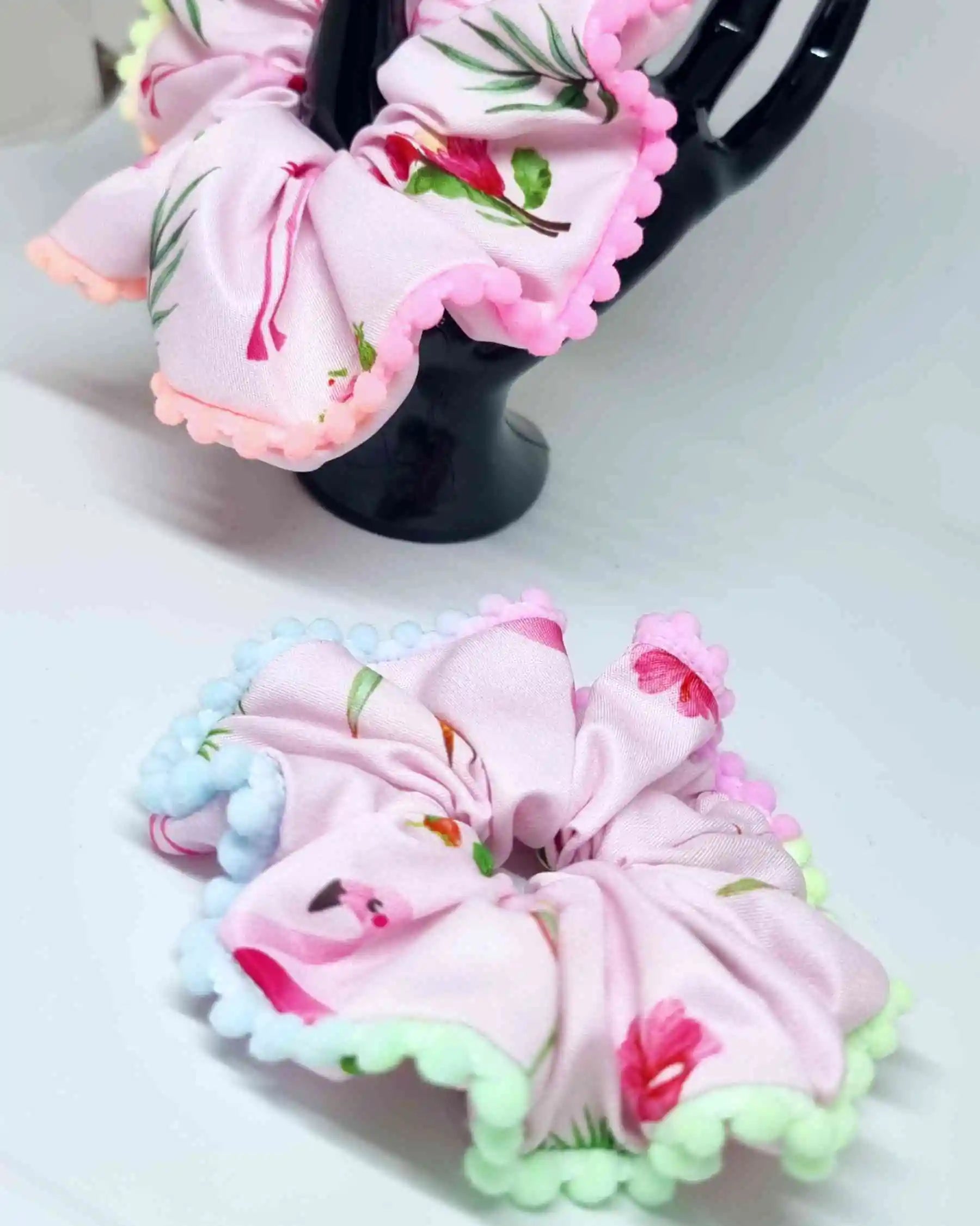 Scrunchie Tropico Flamenco BorlasLos Scrunchie Tropico Flamenco con borlas son una elección ideal para el cabello. Están hechos a mano en dos tamaños: 11 cm y 14 cm. Estampado tropical con borlas decorativas, para añadir un toque de color al verano. Cada