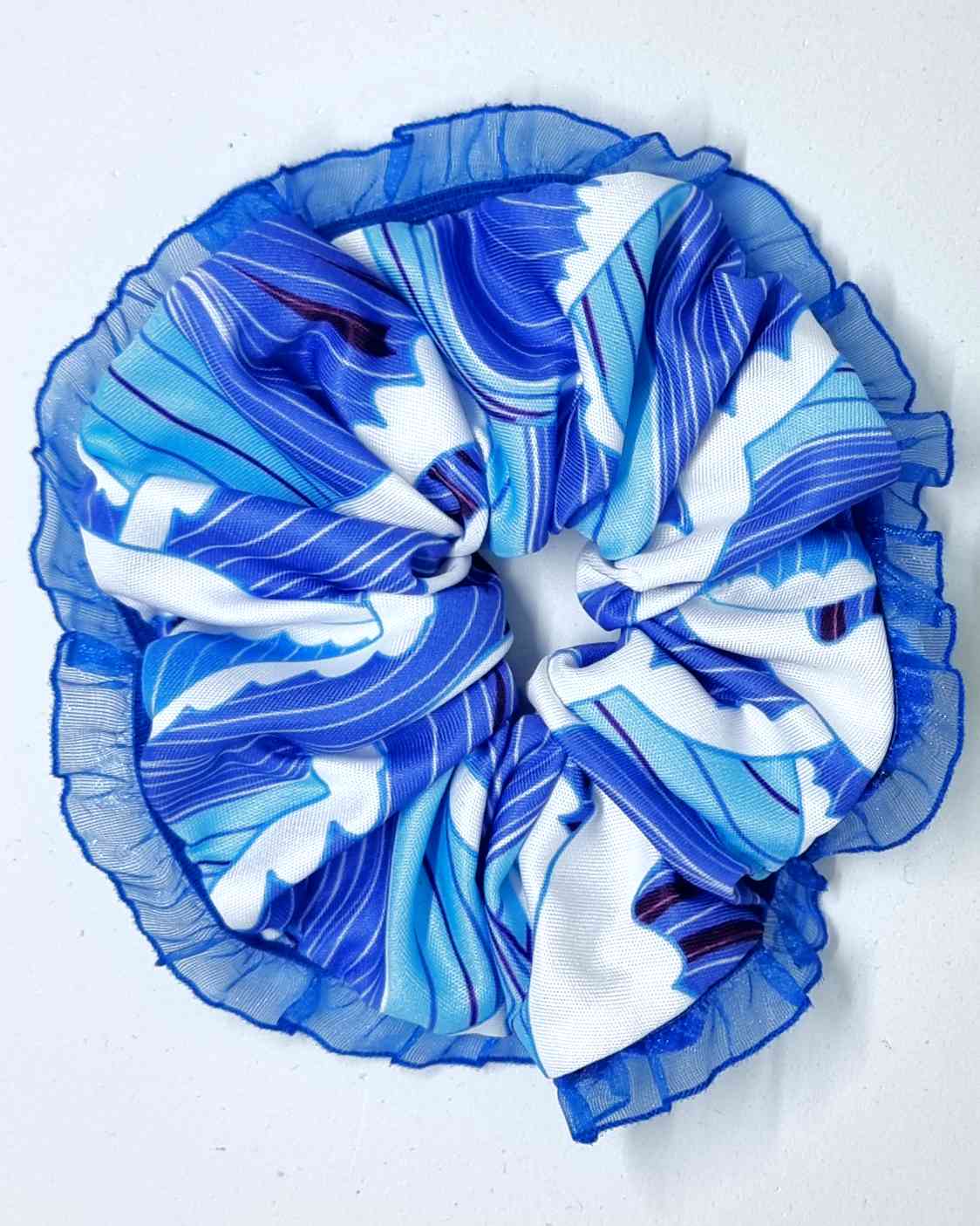 Scrunchie Del Mar | HandmadeColetero Del Mar Descubre un look único y lleno de elegancia con nuestro coletero. Hecho con tejido en tonos azules que evocan los colores del mar y la playa, borde de encaje azul delicado para un acabado sofisticado. Cada uno