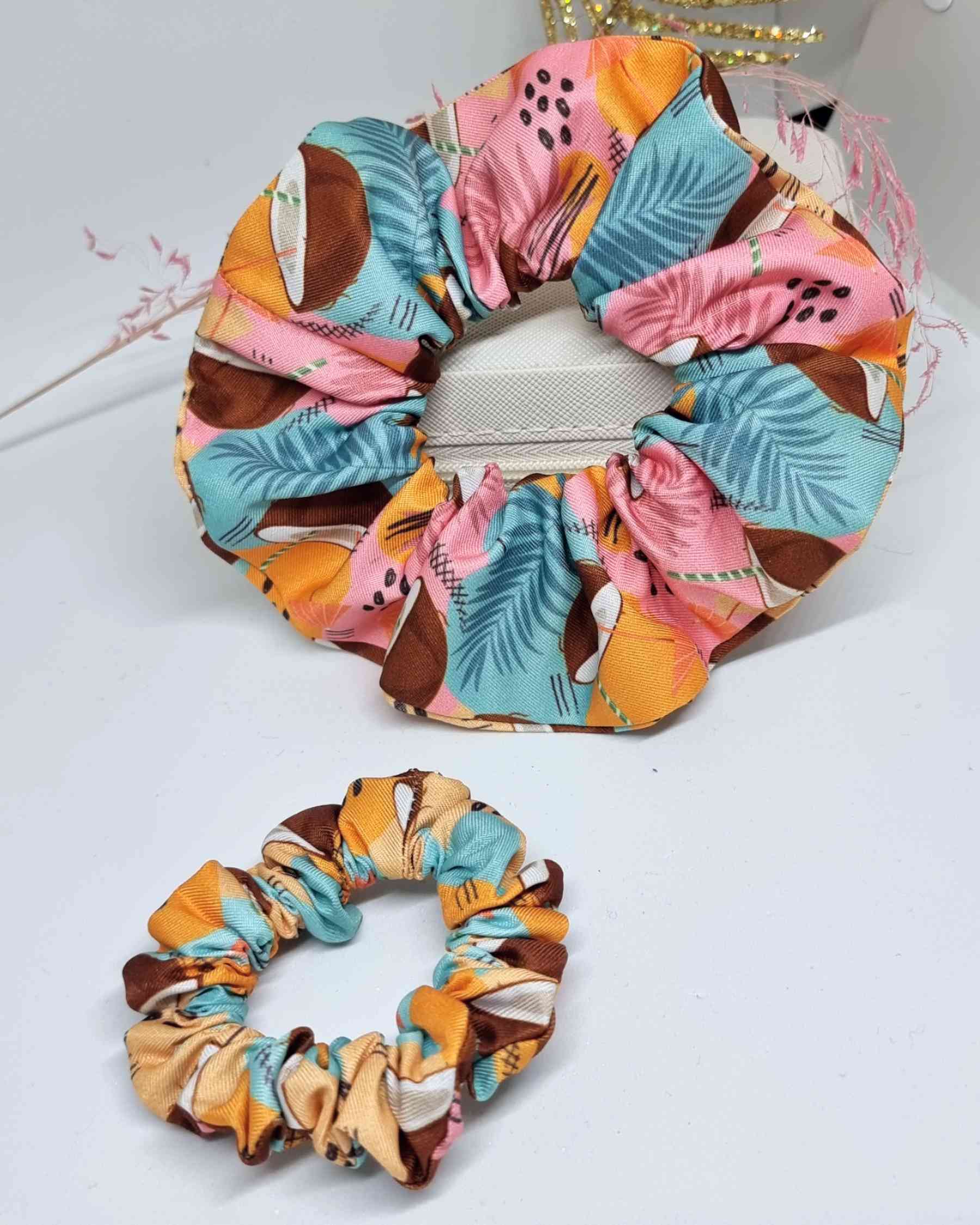 Scrunchies Mama & Me KoKo | Colección tropical verano¡Disfruta este verano en familia con los divertidos Scrunchies Mama & Me KoKo! Esta colección tropical ofrece un set de gomas de pelo de 12 cm para mamá y de 7 cm para tu pequeña. ¡Hechas a mano con muc