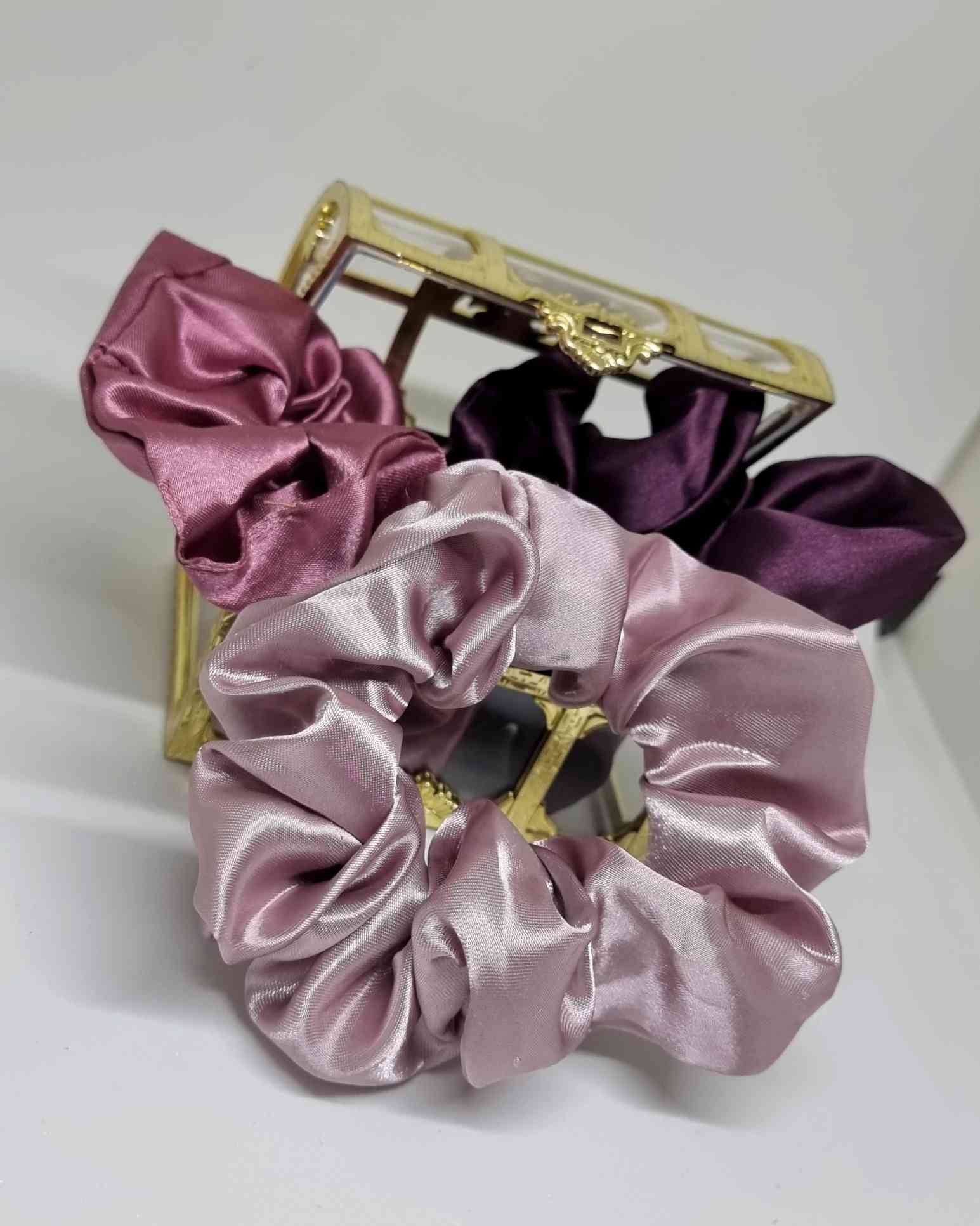 Scrunchie Box Satin Perlado LilaScrunchie Box Satin Perlado ¡Aprovecha este maravilloso set de 3 scrunchie box satin perlado lila para cuidar tu cabello y destacar tu estilo! Hechos a mano, con tamaño de 12 cm, estos coleteros son la opción perfecta para