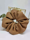 Scrunchie Castaño - Selección OtoñoColetero selección otoño El scrunchie de tono camel hecho a mano con detalles artesanales es la prenda ideal para esta temporada de otoño. Suave y práctico, cuida tu melena sin dañarla mientras te ofrece un estilo único