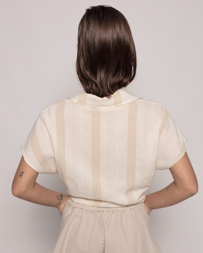 Camisa Alegria Rayas NudoCamisa semi-crop anudada Camisa de rayas con cuello solapa y manga corta. Cierre frontal con botones. Detalle nudo frontal. Talla de la modelo: S. Altura modelo: 1,65 m. Composición: 100% Algodón Envío: Suiza 2/3 días Europa 5/9 d