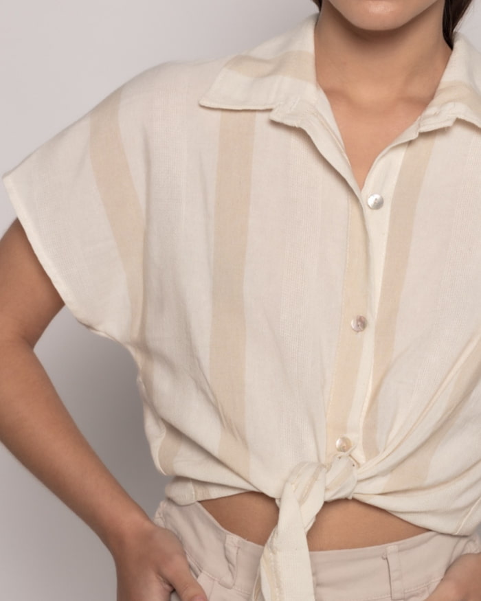 Camisa Alegria Rayas NudoCamisa semi-crop anudada Camisa de rayas con cuello solapa y manga corta. Cierre frontal con botones. Detalle nudo frontal. Talla de la modelo: S. Altura modelo: 1,65 m. Composición: 100% Algodón Envío: Suiza 2/3 días Europa 5/9 d