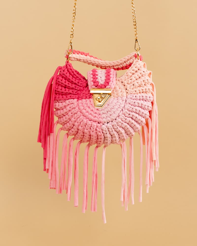 Bolso Tejido Chic LiliesBolso Tejido Crochet Chic Lilies Eleva tu estilo con el Bolso Tejido Chic Lilies. Su diseño en tonos rosados y su asa en el mismo material, cierre en contraste color gold, lo hacen sofisticado y exclusivo. Además, su cadena permite