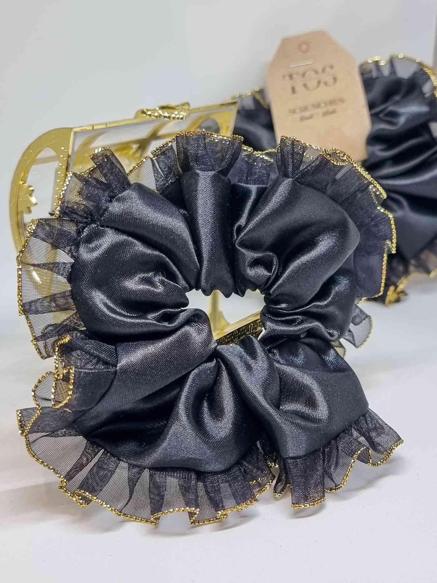 Scrunchie Glam Gold XLColetero Glam Gold XL- Selección Otoño Embellece tu peinado con este coletero hermosamente diseñada a mano. Está fabricada con suave satén y contraste con encaje en tono dorado. Estas Scrunchies cuidan tu cabello protegiéndolo de dañ