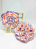 Scrunchie Ethnic Style - Selección OtoñoColetero Étnico Selección Otoño ¡Añade estilo a tu look con este Scrunchie étnico estampado! Esta selección moderniza tu look con hermosos tonos y un estampado vibrante en tonos morado y naranja. ¡Estas tonalidades