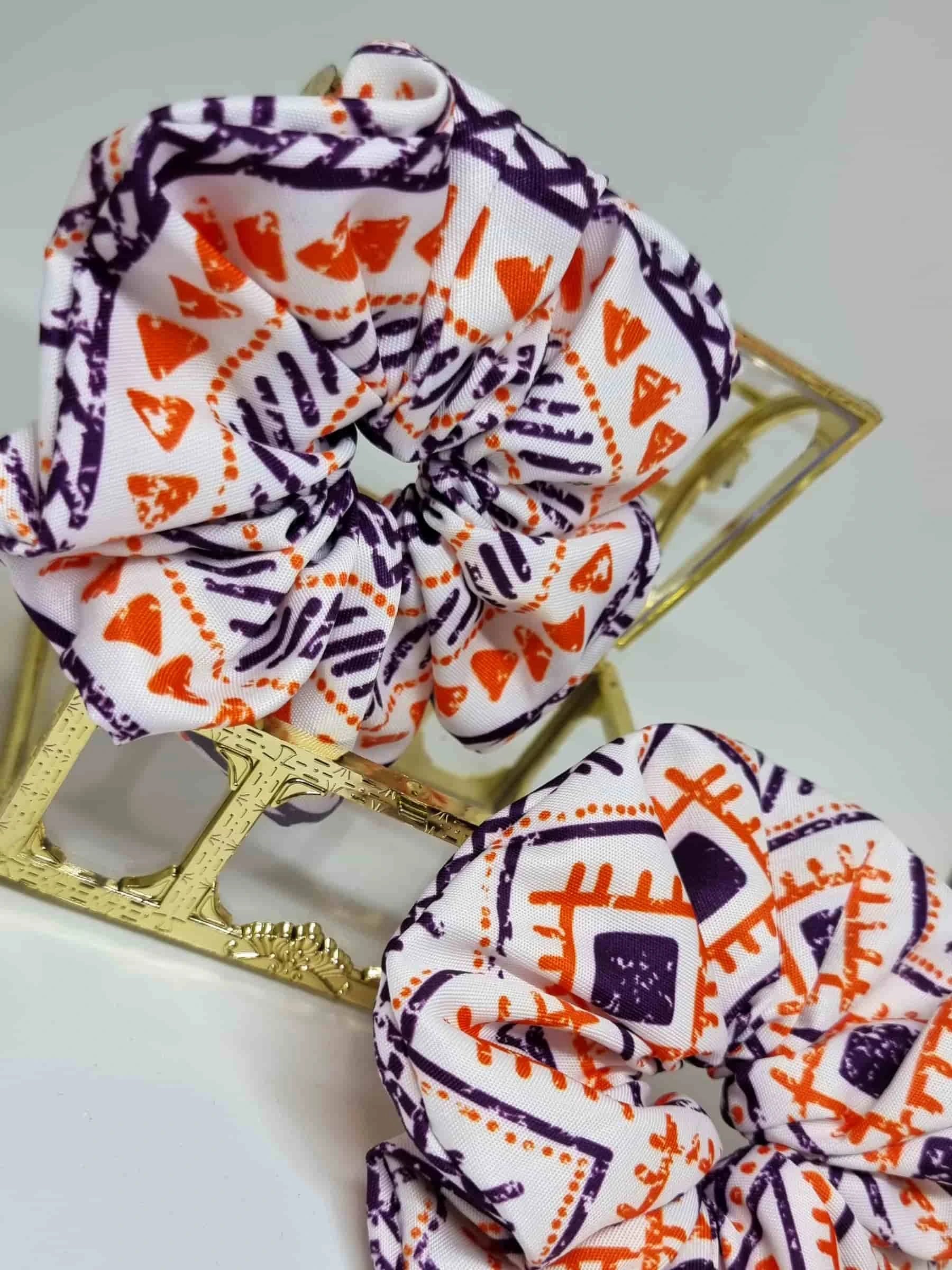 Scrunchie Ethnic Style - Selección OtoñoColetero Étnico Selección Otoño ¡Añade estilo a tu look con este Scrunchie étnico estampado! Esta selección moderniza tu look con hermosos tonos y un estampado vibrante en tonos morado y naranja. ¡Estas tonalidades