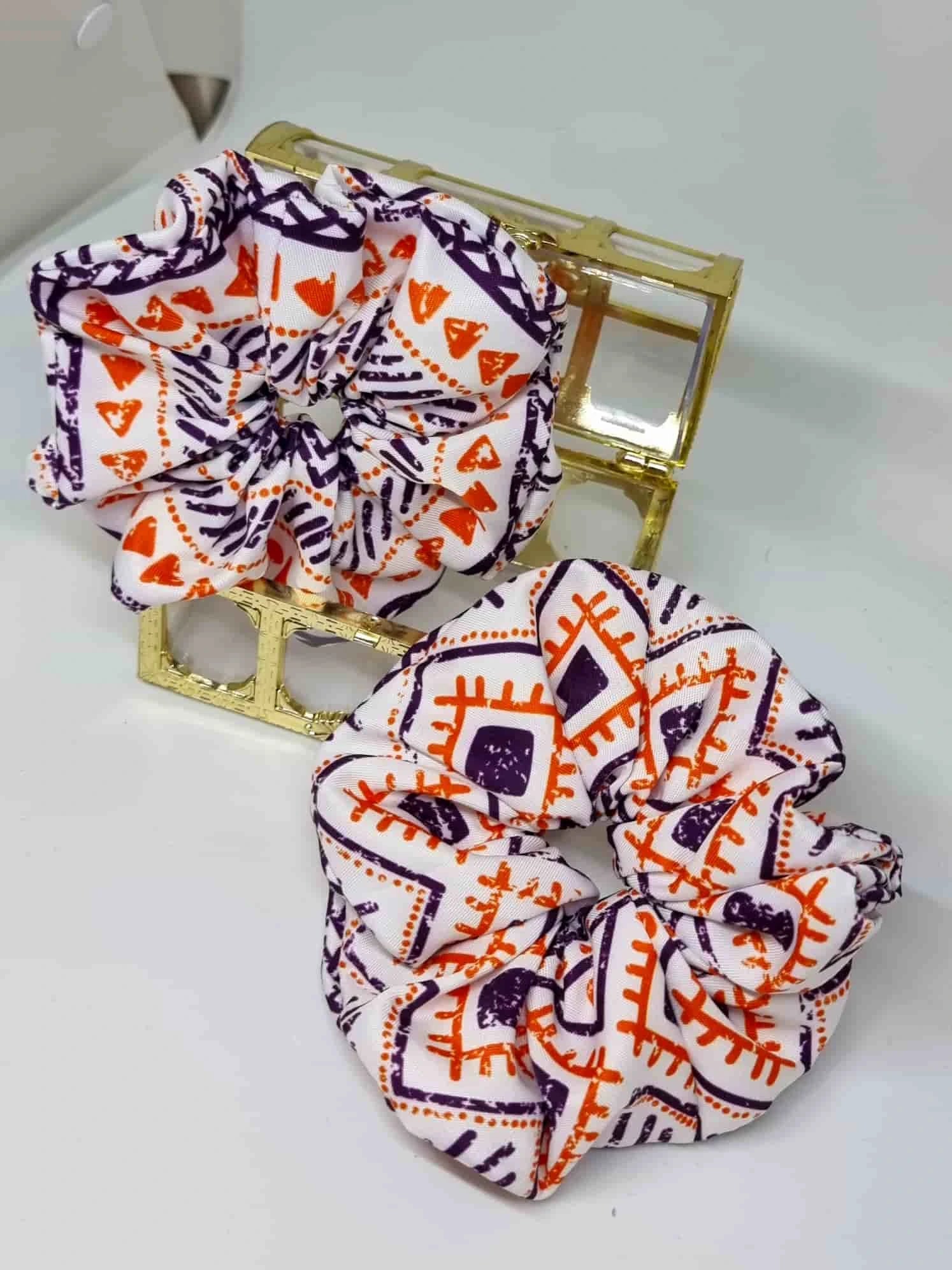 Scrunchie Ethnic Style - Selección OtoñoColetero Étnico Selección Otoño ¡Añade estilo a tu look con este Scrunchie étnico estampado! Esta selección moderniza tu look con hermosos tonos y un estampado vibrante en tonos morado y naranja. ¡Estas tonalidades