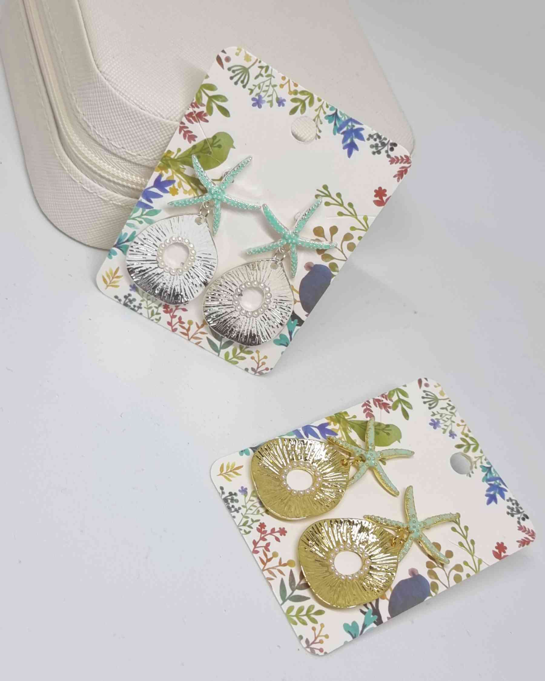 Pendientes Estrella De Mar Perlas PlateadoPendientes estrella de mar ¡Los Pendientes Estrella De Mar Perlas Plateado son la combinación perfecta para conseguir un look de verano! Estos pendientes veraniegos con pequeñas perlas plateadas son una preciosa a